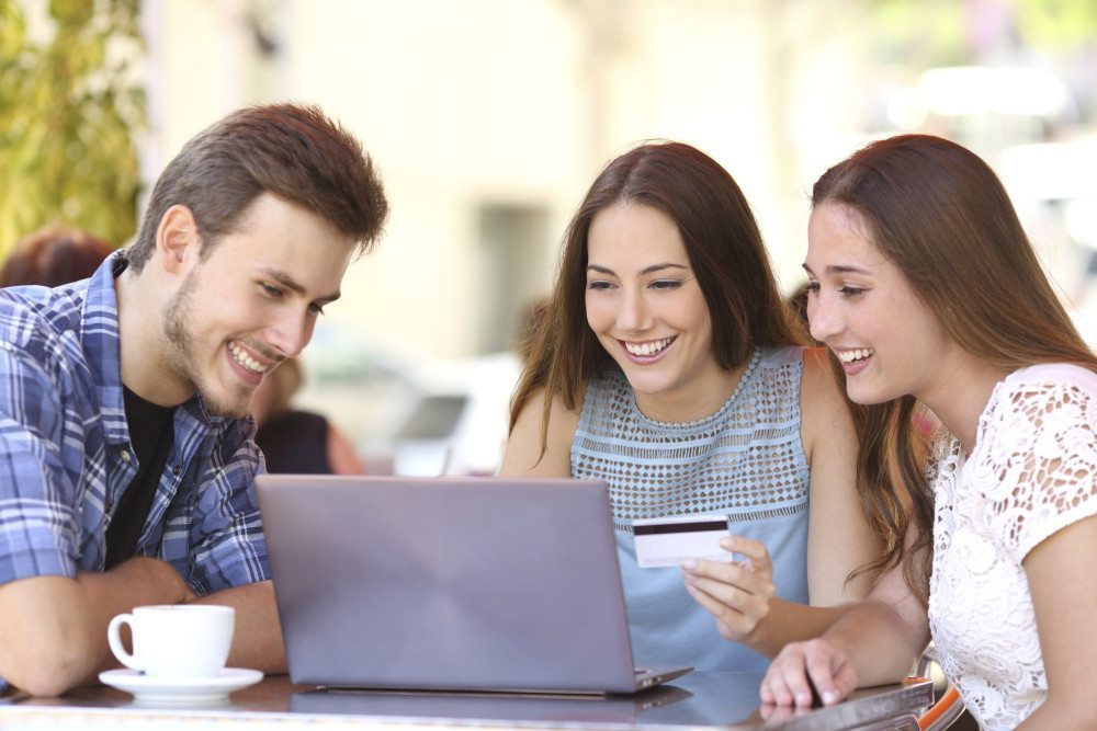 Friends shopping online with a credit card and a laptop shopping on amazon