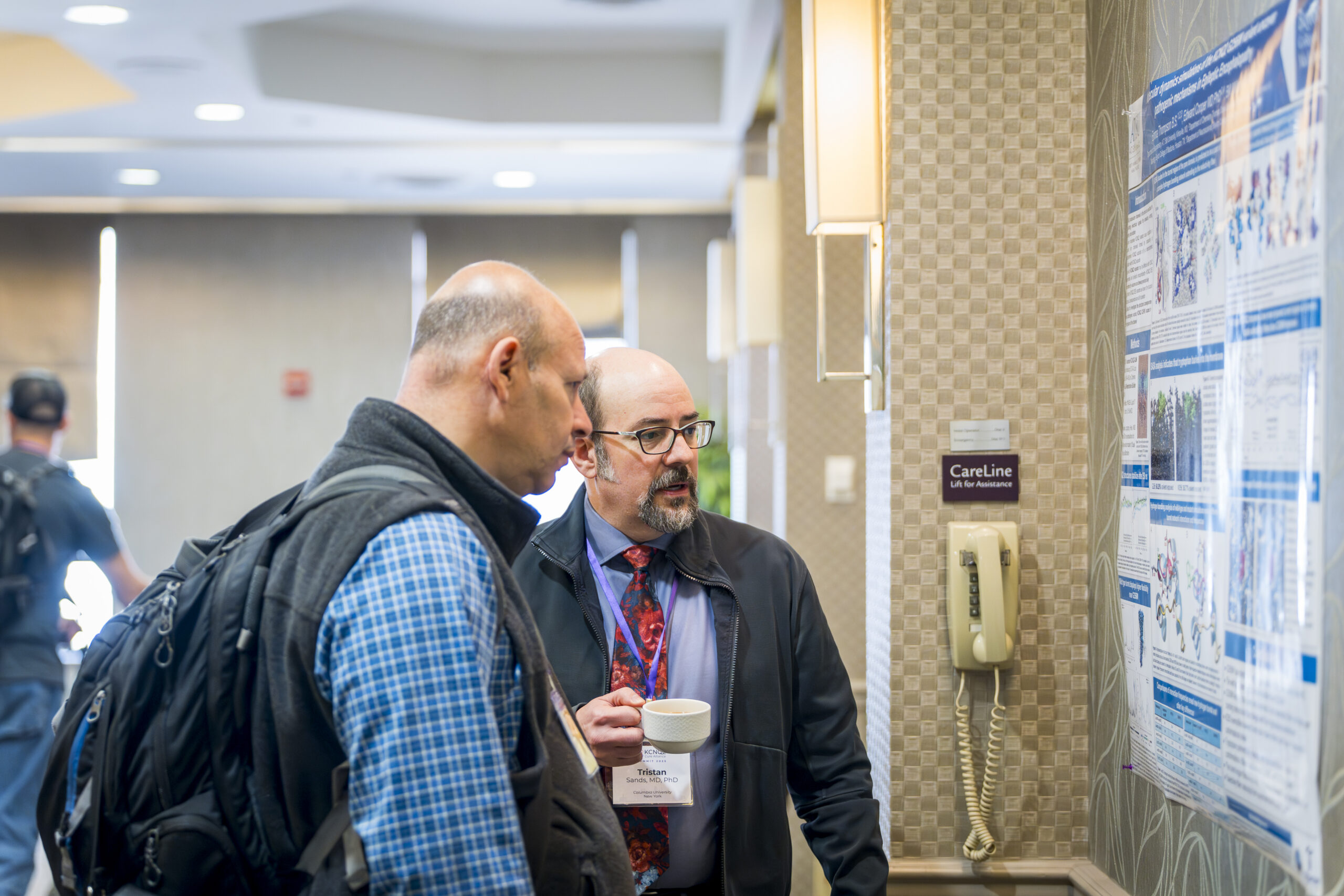 Researchers discuss a KCNQ2 research poster at the Family Summit