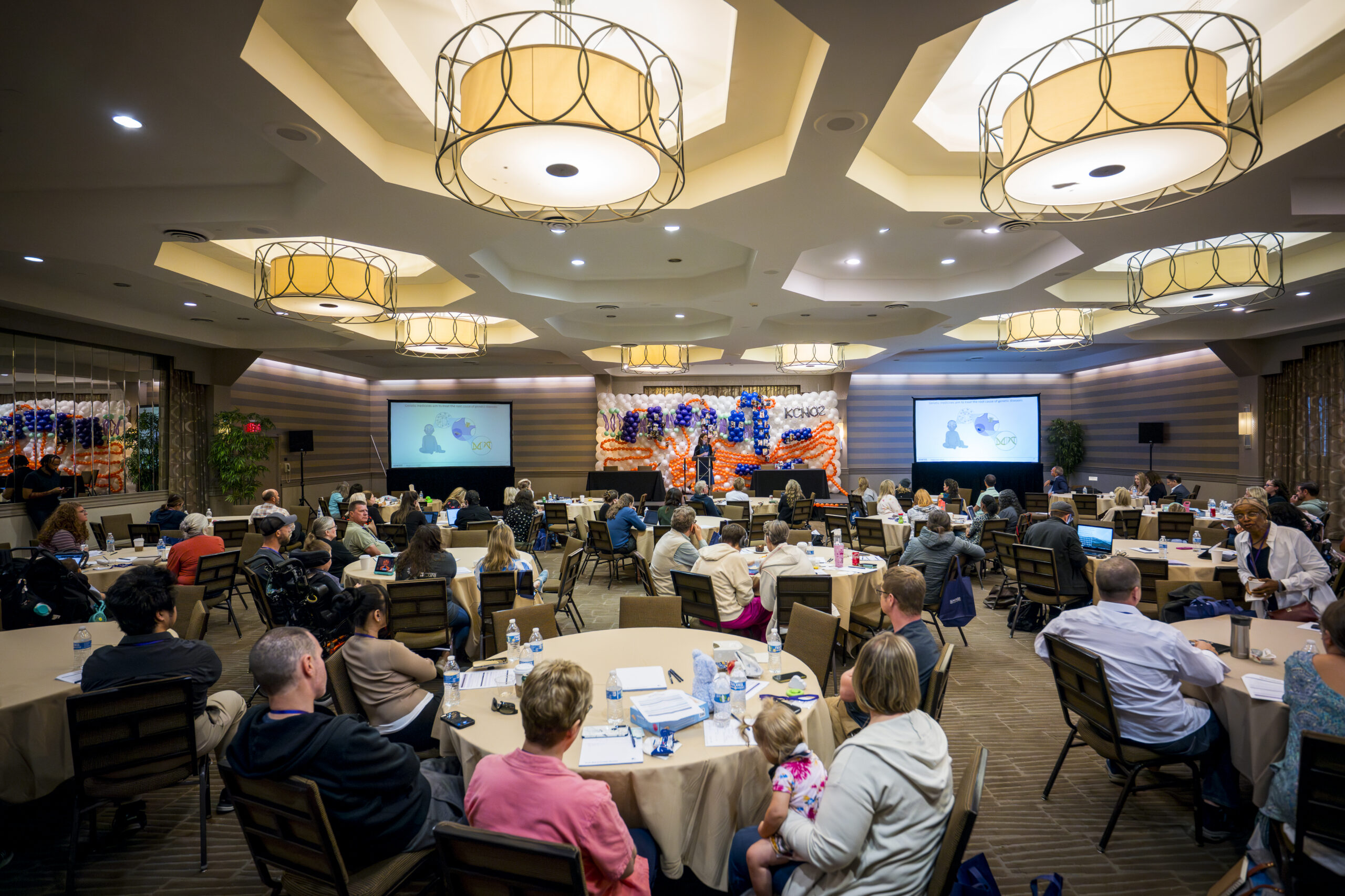 Families and professionals at round tables during a Summit general session