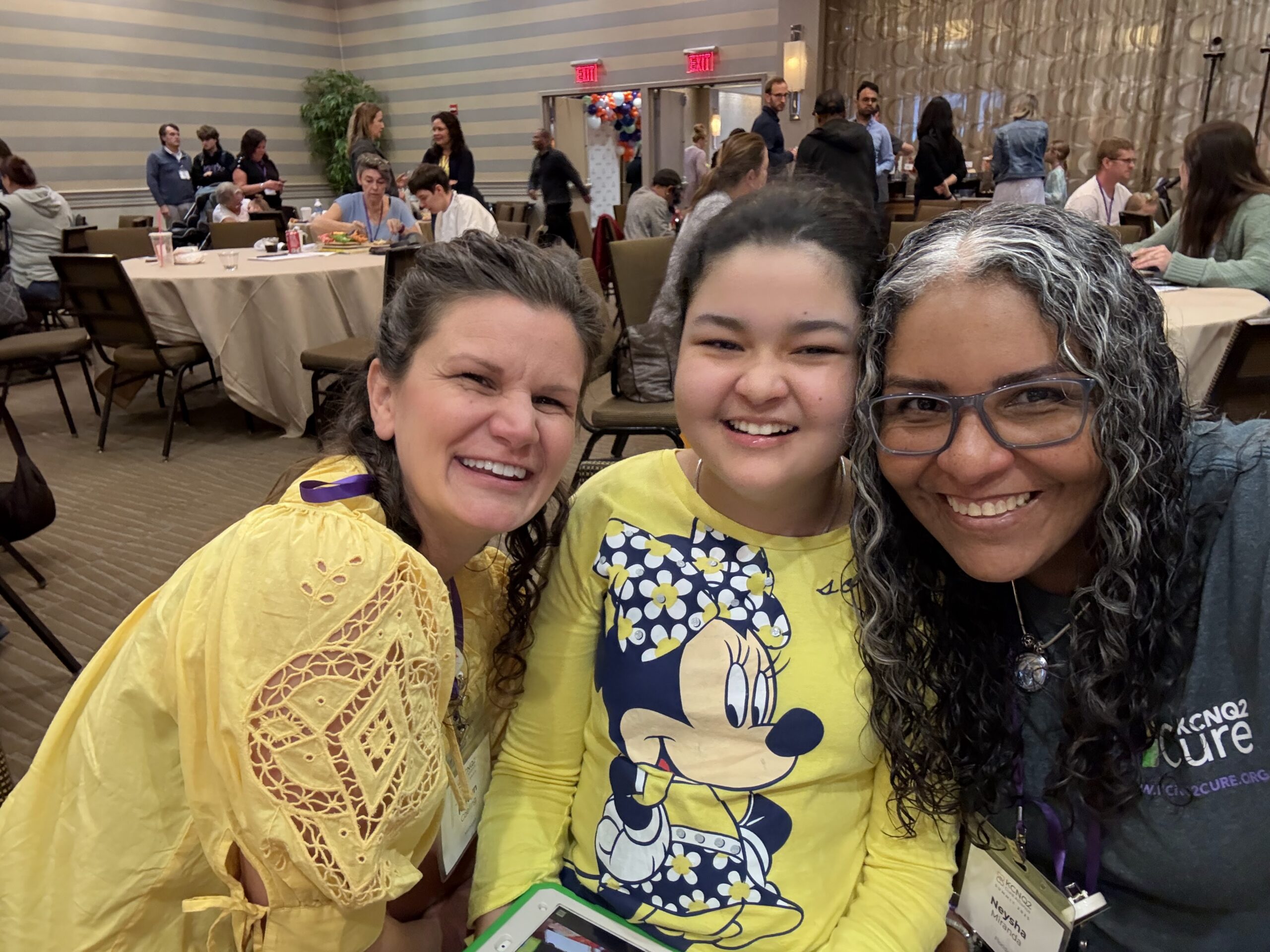 Ivanna and her mom Neysha smiling with a friend at a KCNQ2 Cure family event