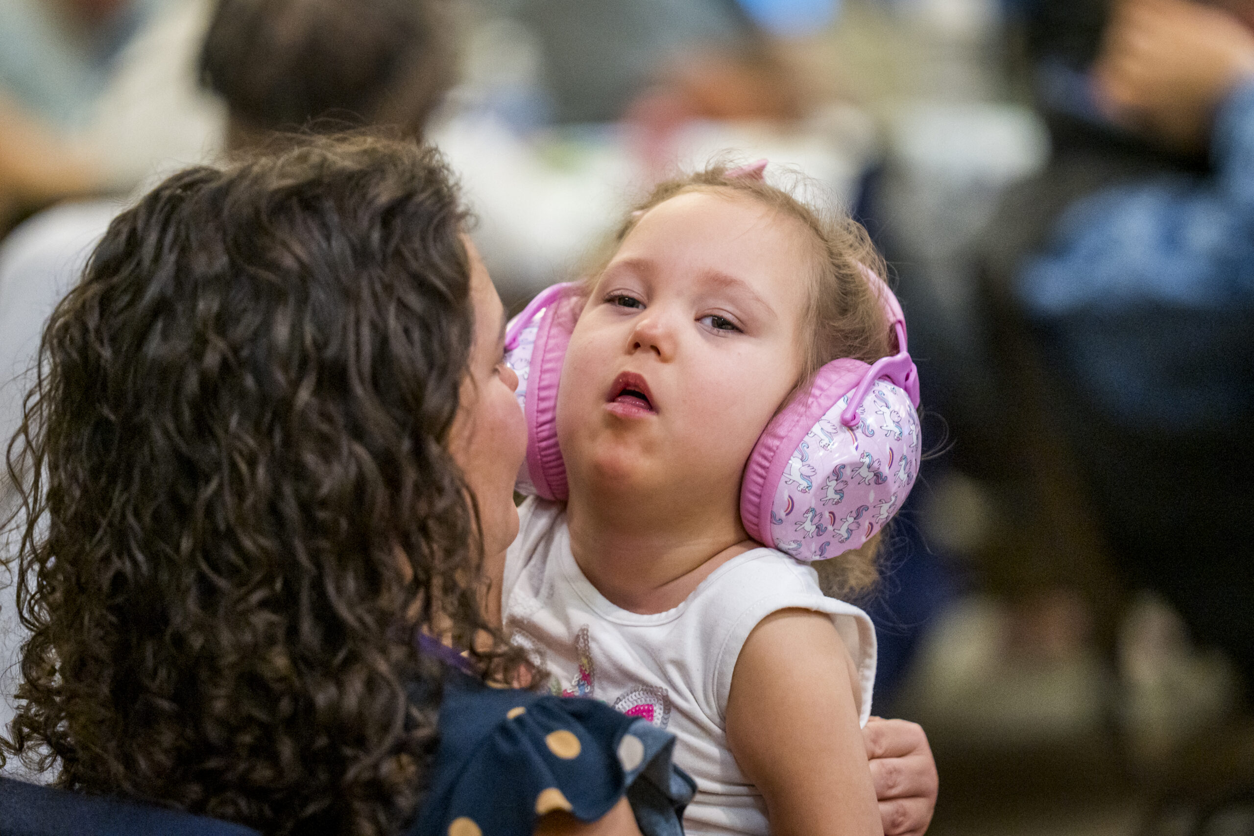 A parent with her young daughter listening to a Summit presentation