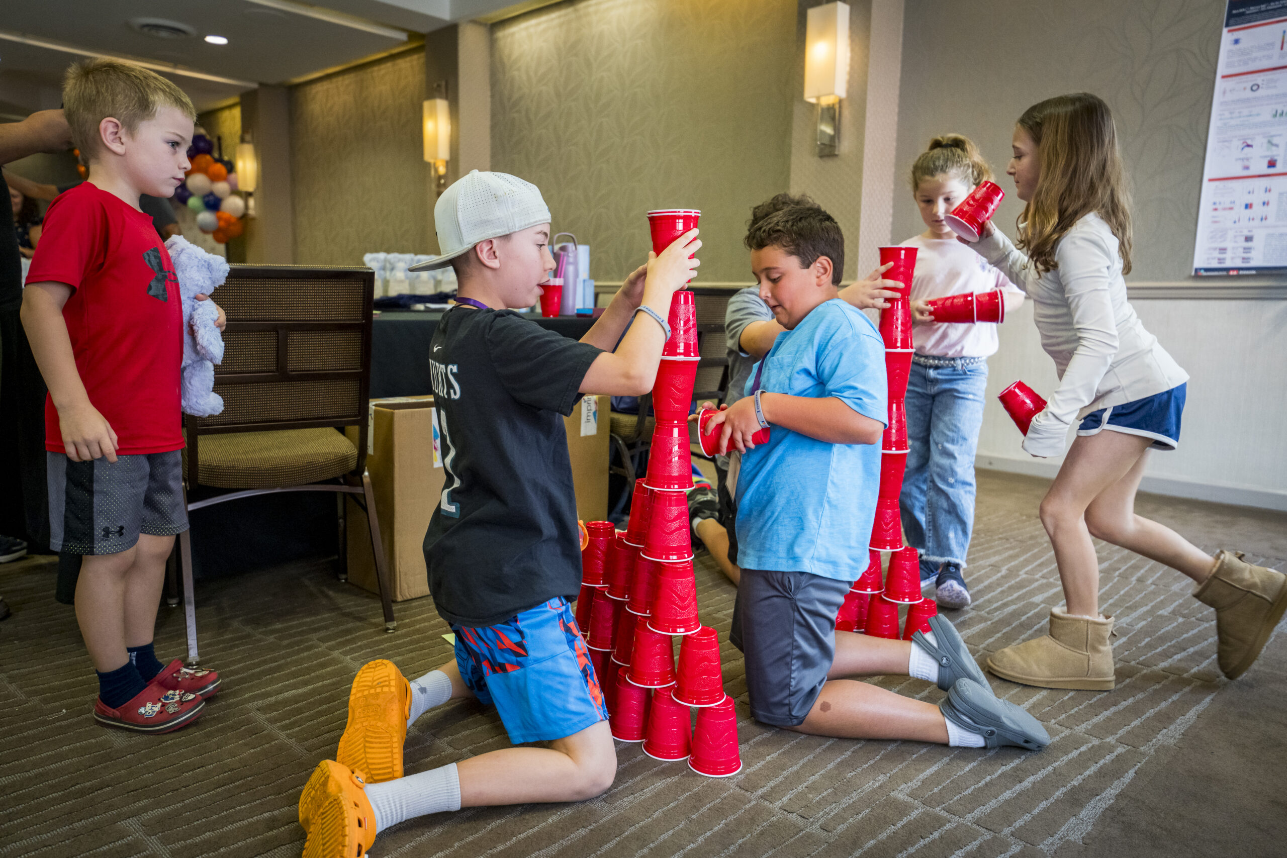 Siblings stacking a tower of red cups together at SuperSibs camp