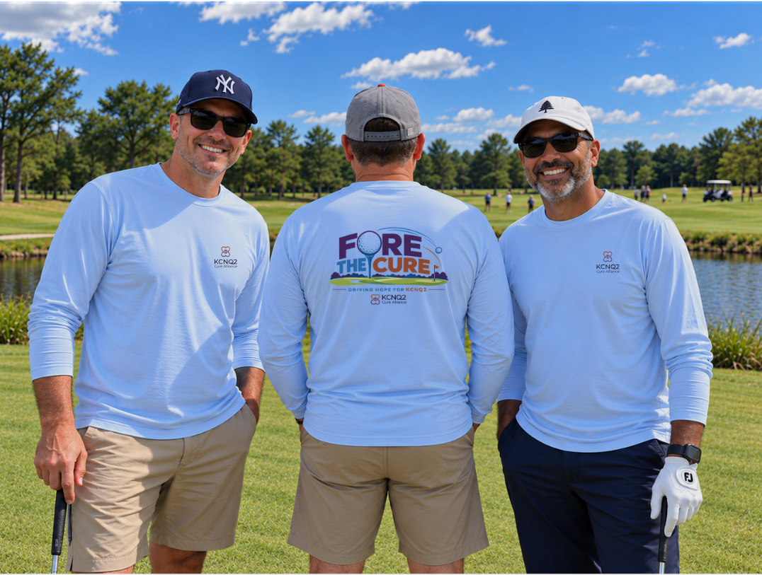 Three golfers in light blue Fore the Cure KCNQ2 shirts on a golf course